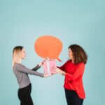 Deux jeunes femmes s'échangent un paquet cadeau sur un fond bleu.